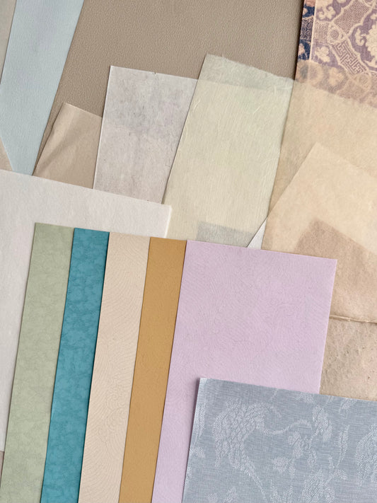 Collection of various textured paper samples in different colors and patterns.